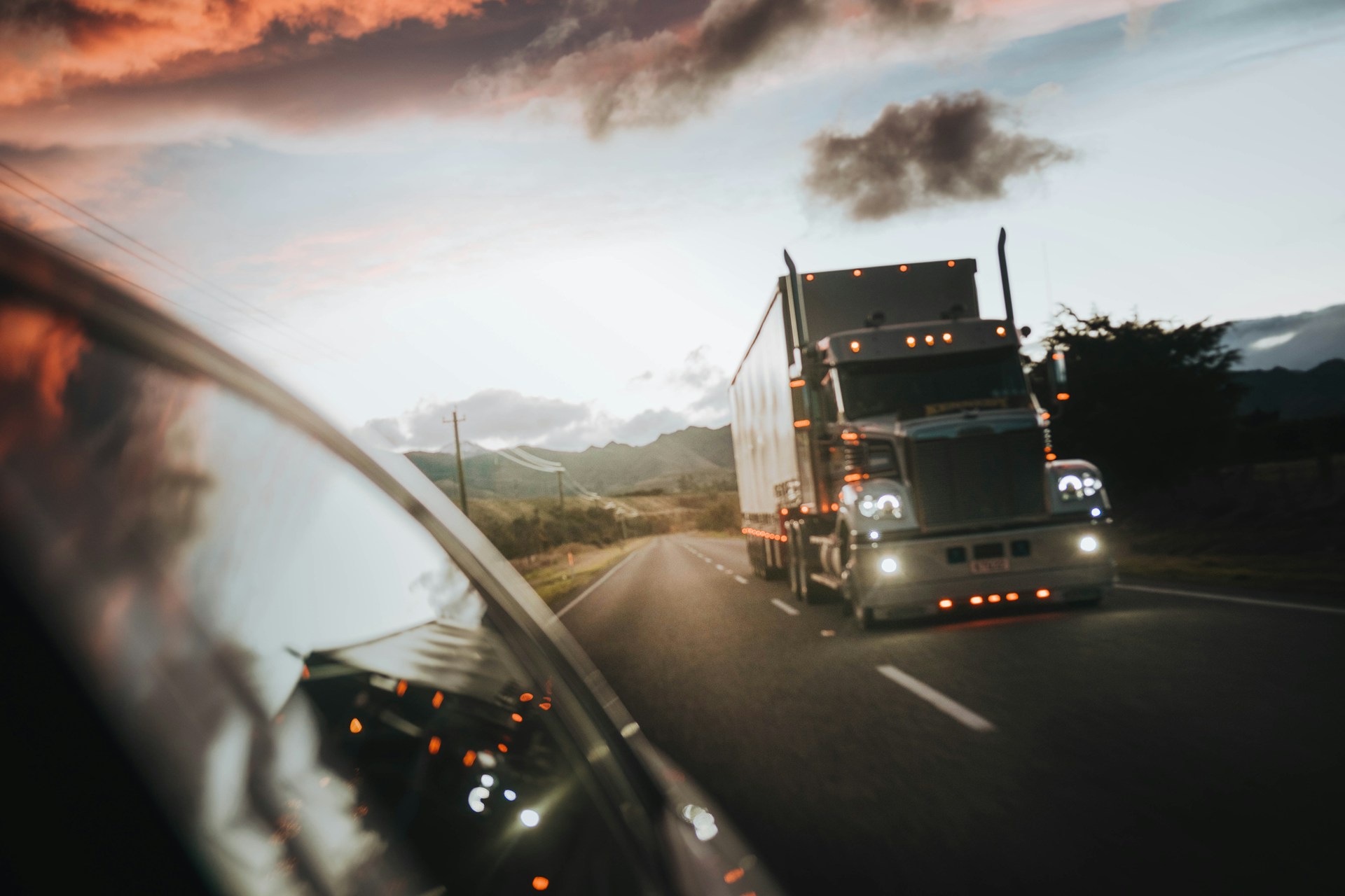 Semi truck driving on a highway at dusk